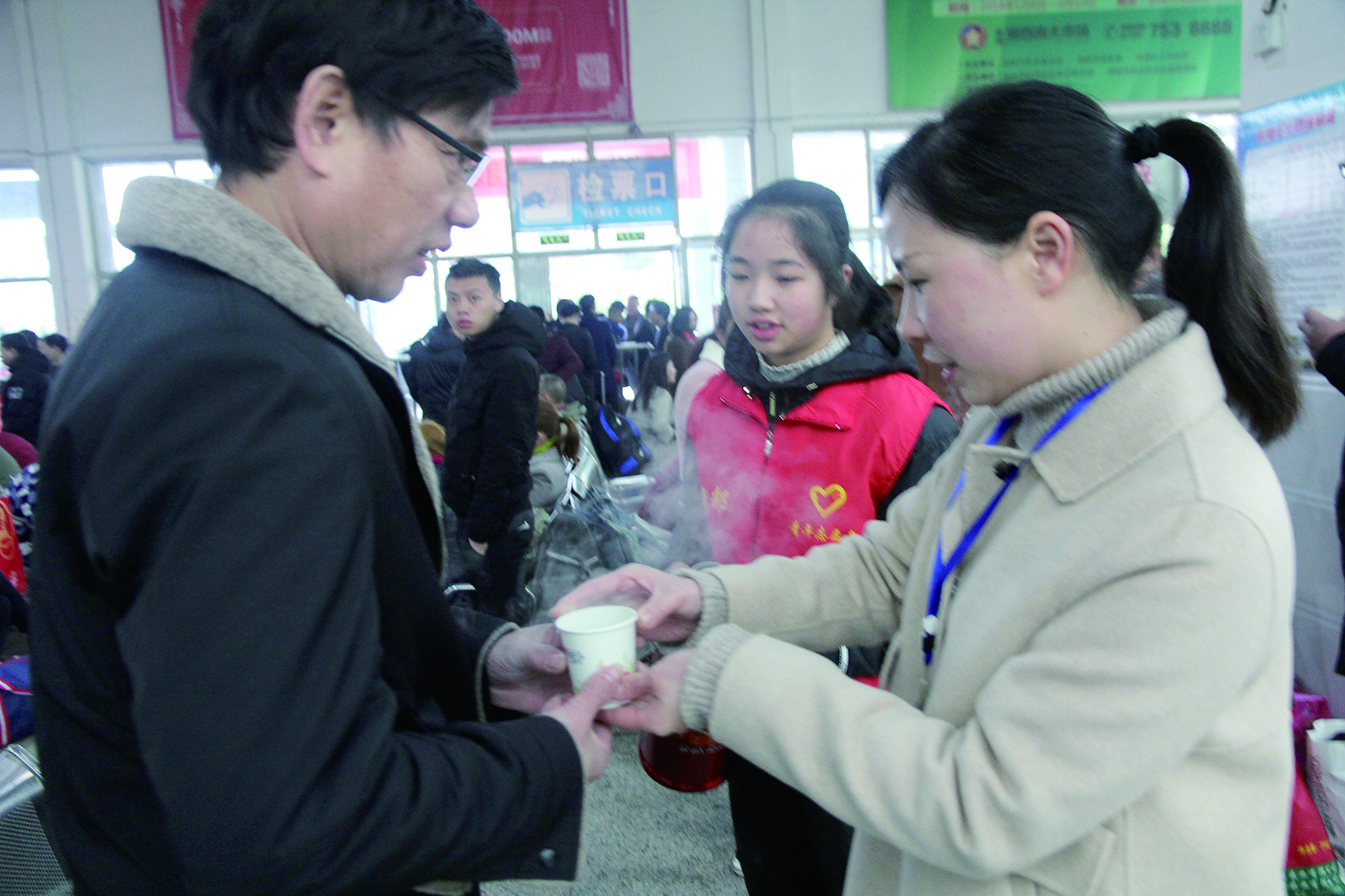 母女服務春運 2月13日，記者在新邵分公司汽車站看到，該分公司安全科副科長李喜梅與其在新邵一中初中部1701班就讀女兒劉嘉怡在車站擔當志愿者。李喜梅在候車室耐心為旅客釋疑解惑，劉嘉怡為旅客遞上一杯杯熱茶，有時母女也相互合作，其樂融融。 祖冠 攝影報道